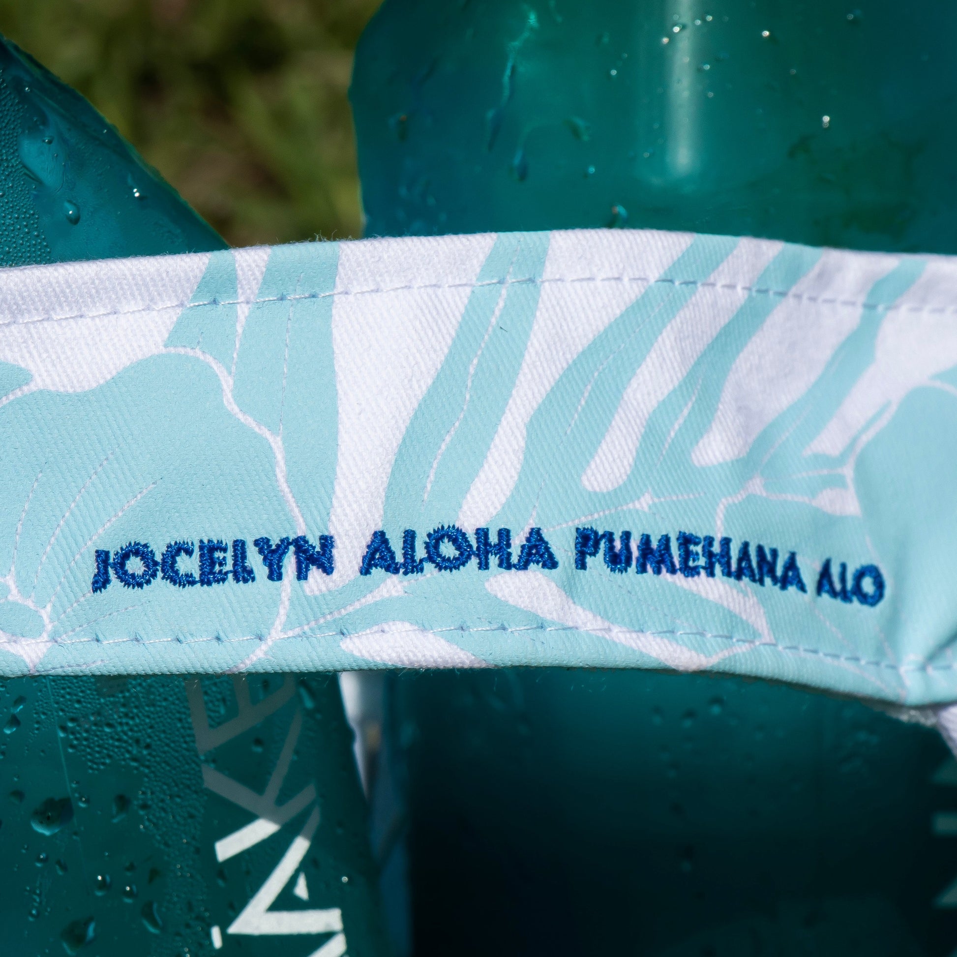 blue embroidered text on fabric with teal bottles