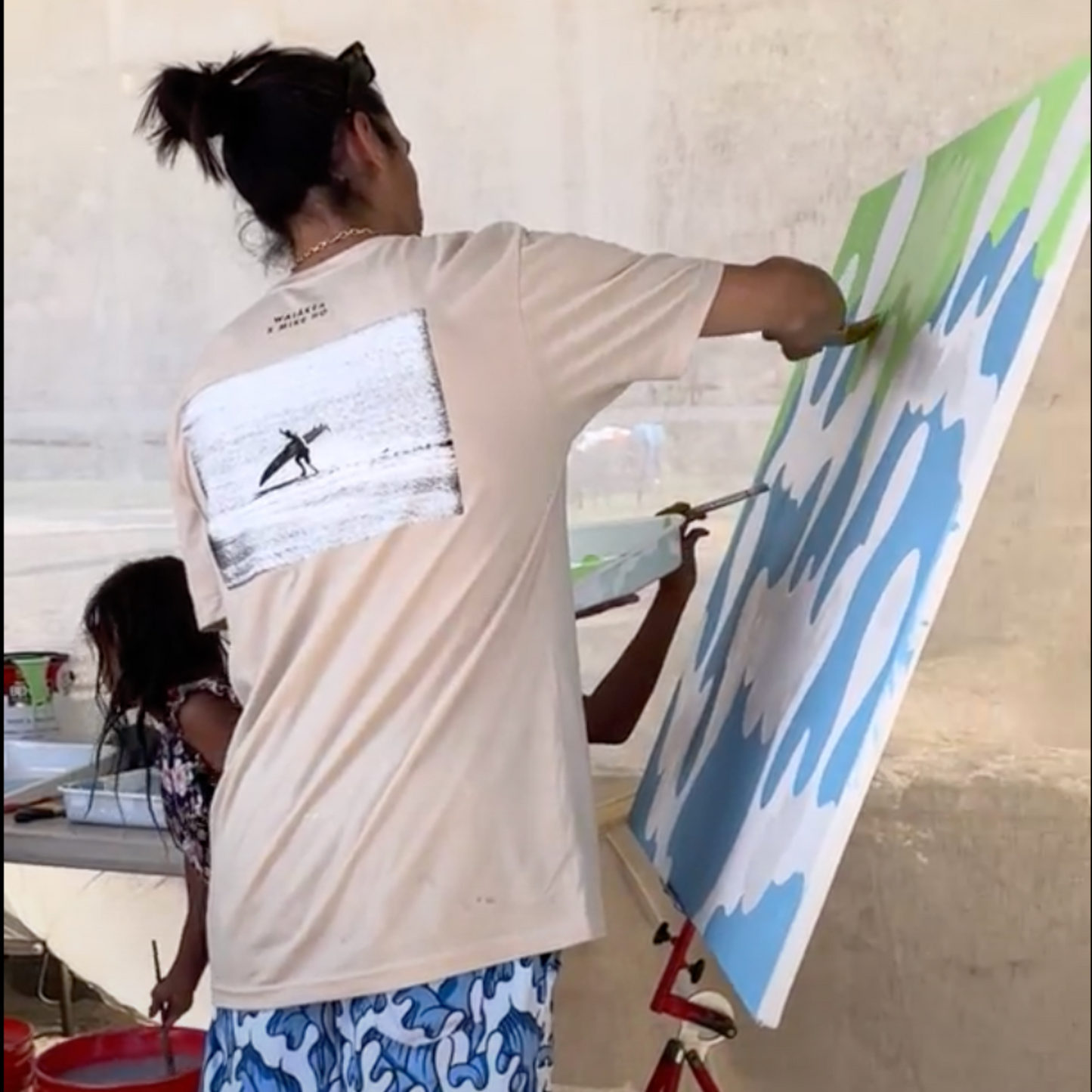 Person painting canvas in casual attire, indoor art activity.