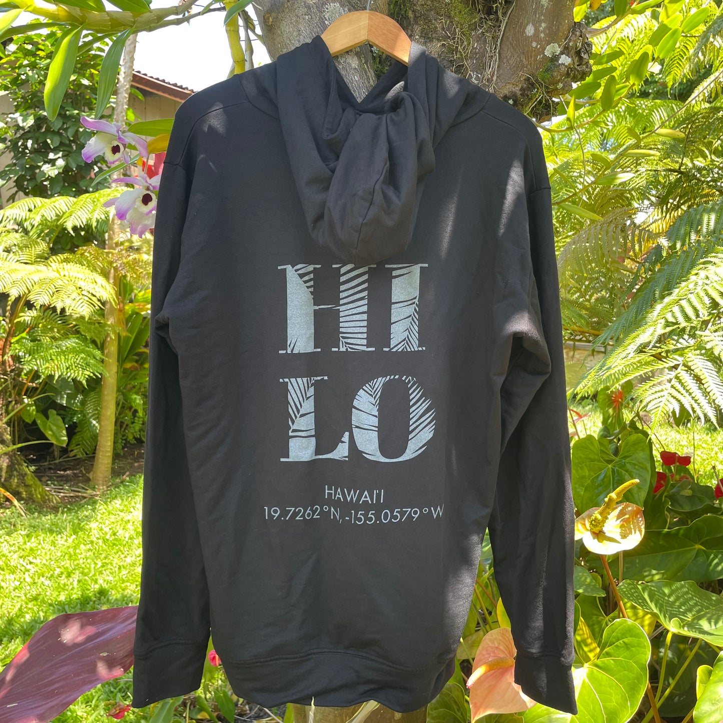 black hoodie with Hilo Hawaii text hanging outdoors