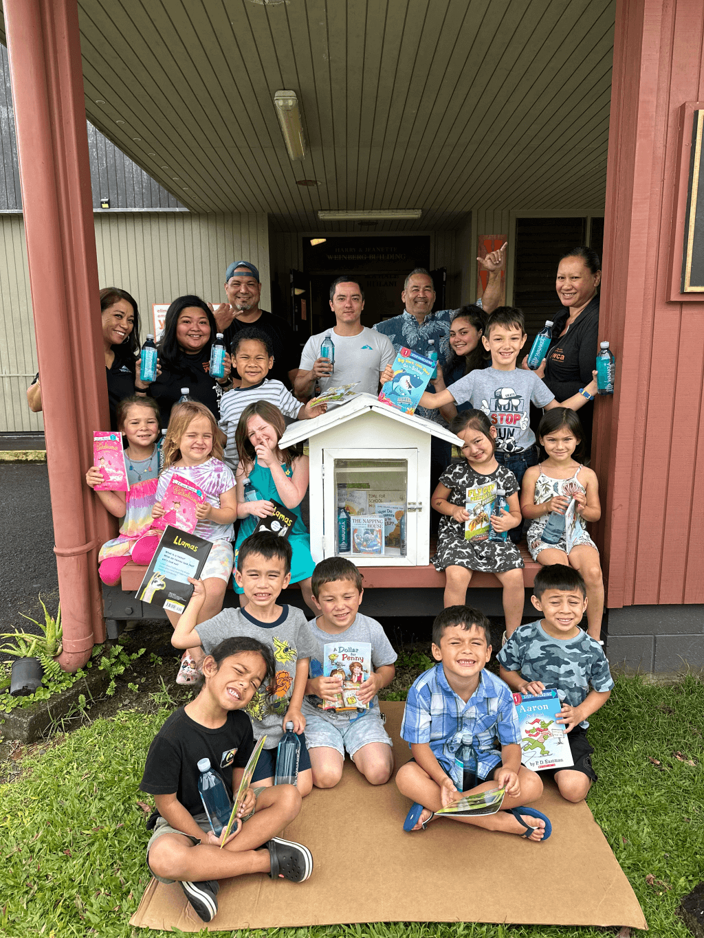 group of children holding books outside library building