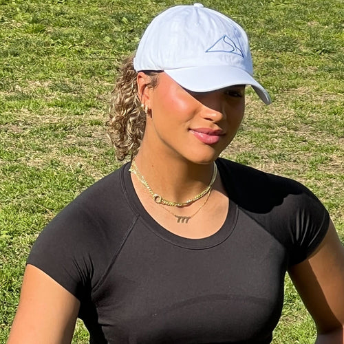 Woman wearing cap and black t-shirt outdoors