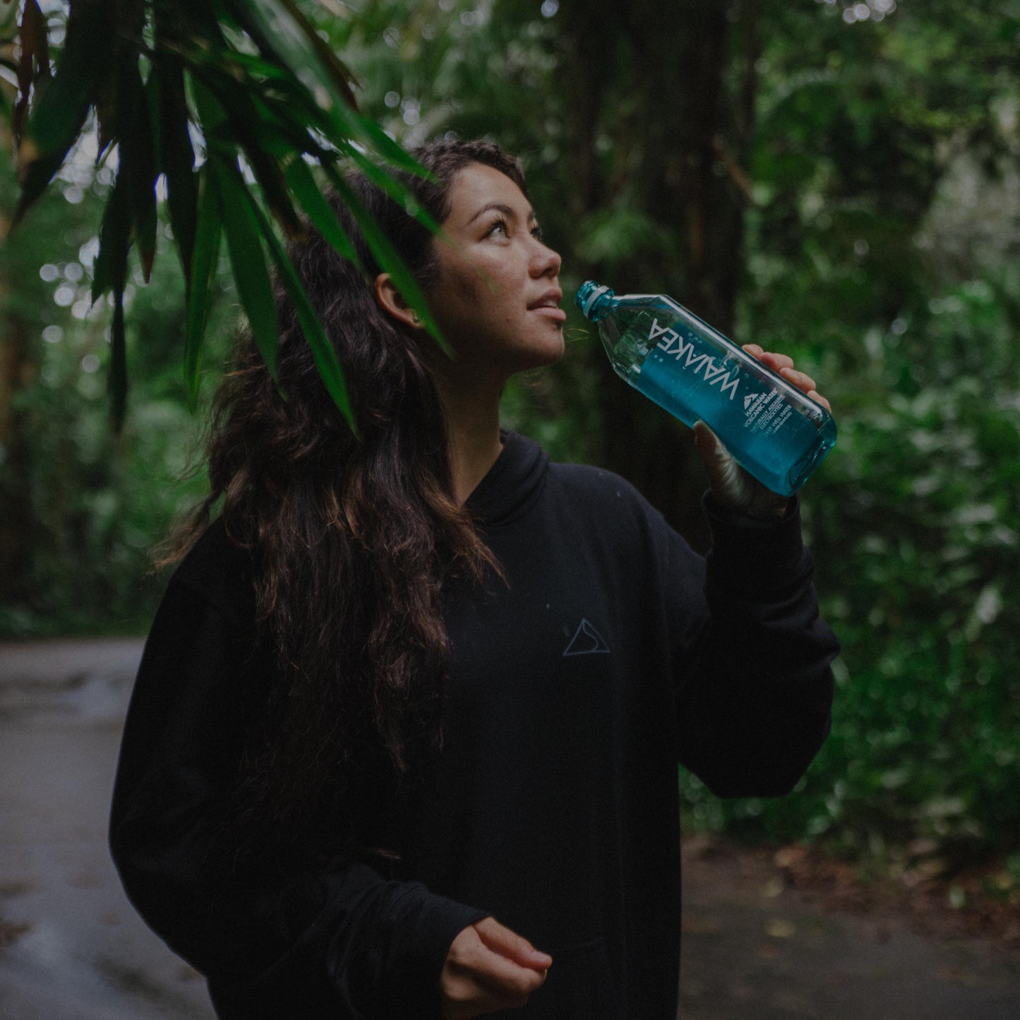 Person drinking water in forest setting