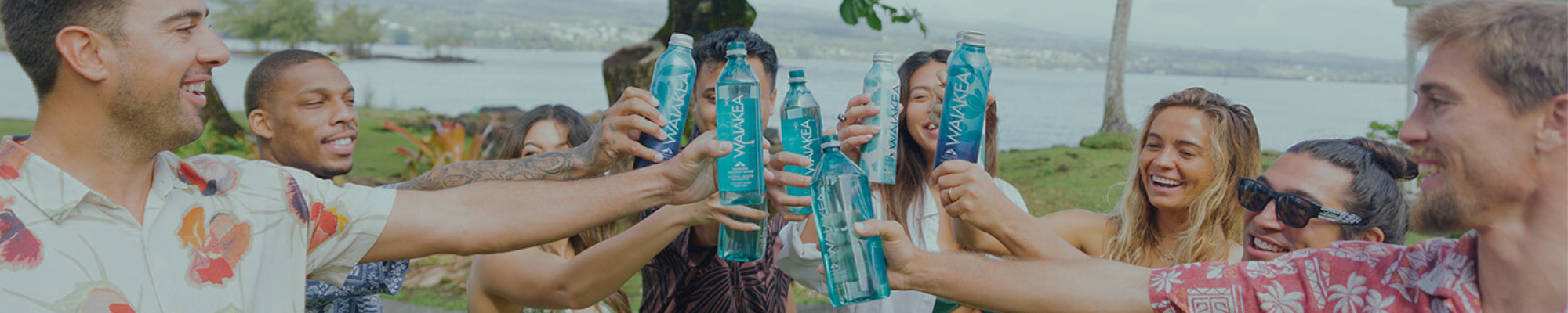 People celebrating with Waiakea water bottles outdoors