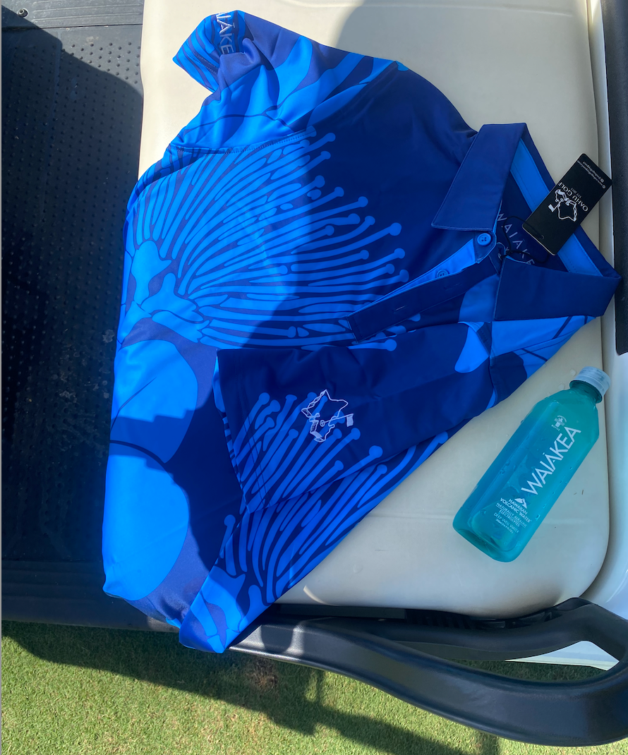 Blue patterned shirt on golf cart with Waiakea water bottle