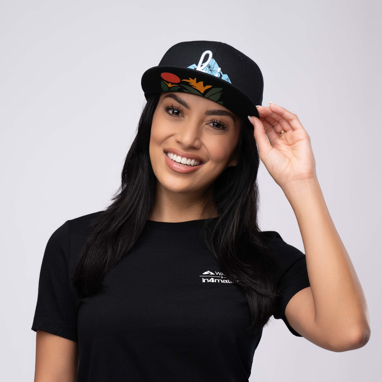 woman wearing a snapback hat with "hi" and volcano logo