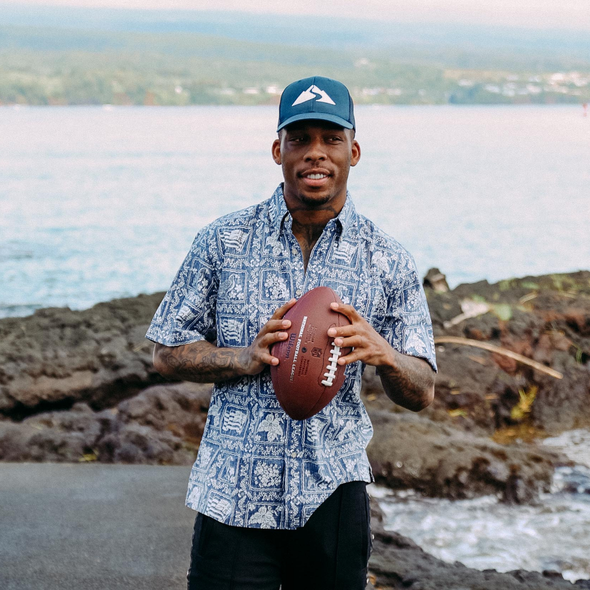 Troy Hill holding football, wearing Waiākea hat