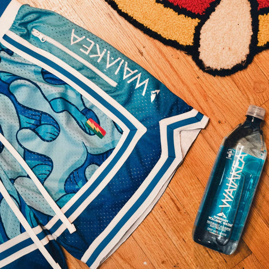 blue shorts with abstract pattern and Waiakea water bottle on wooden floor