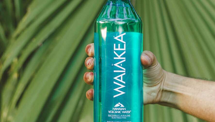 Hand holding Waiakea volcanic water bottle.