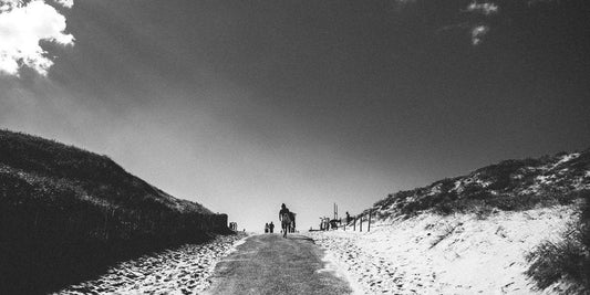 Monochrome photo of surfer heading over a sandy hill