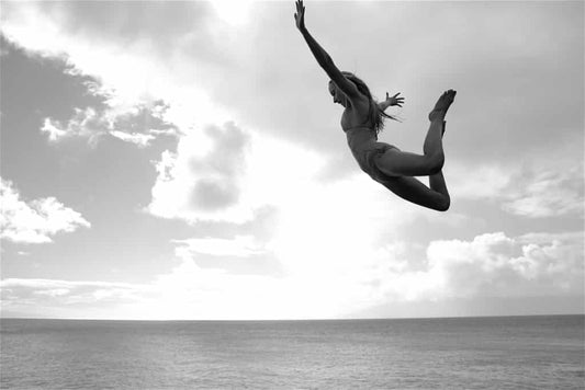 Monochromatic image of woman belly-flopping into the ocean