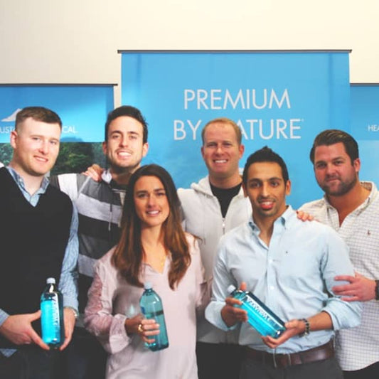 The Waiakea team each holding a bottle of Waiakea