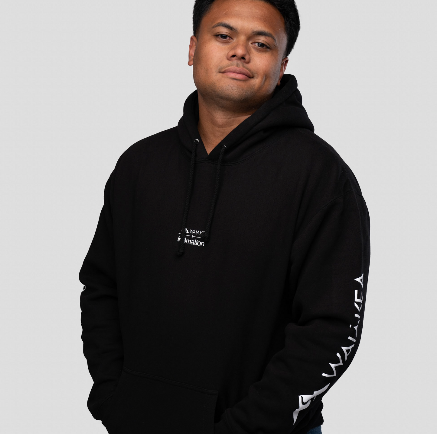 man wearing black hoodie against gray background