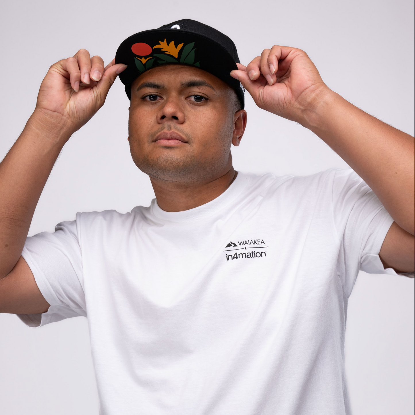 man showcasing a hat with florals on the underside of the bill