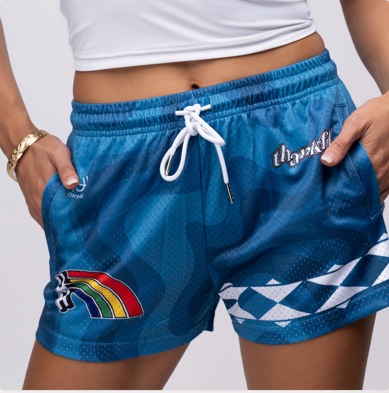 Blue graphic shorts with rainbow and thankful design.