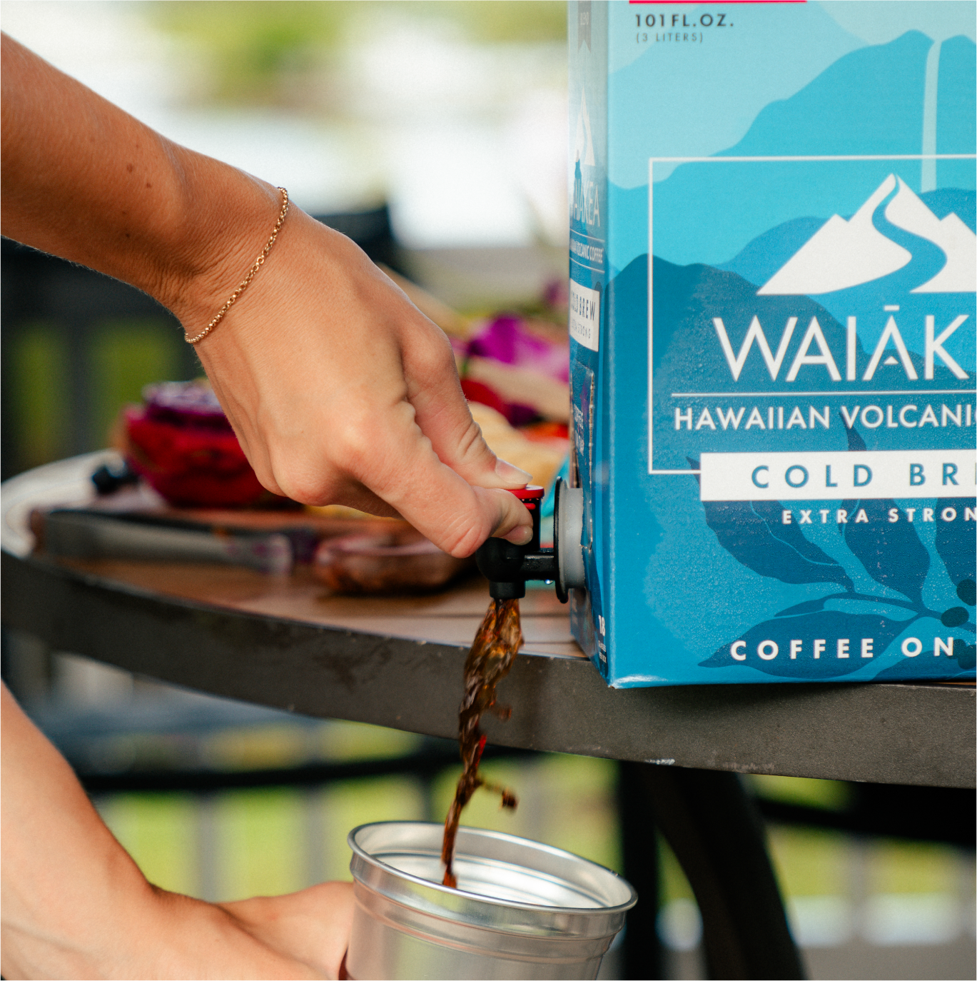 Hand pouring Waiākea Hawaiian volcanic cold brew coffee into cup